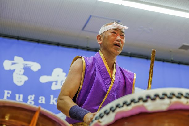 鉢巻を締めて太鼓を打つ奏者